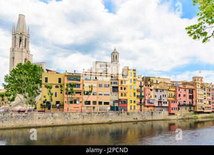 Banks of the River Onyar with the Basilica de Sant Feliu and Cathedral belltower towering over the old town hanging houses of Girona, Catalonia, Spain Stock Photo