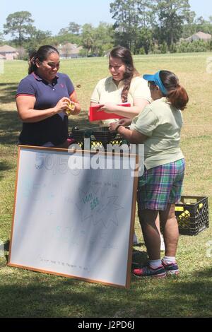 Irish Demaree (left), a medical support assistant at Fort Stewart, Ga., collects golf balls from members of the Marne Community and Spouses Club (MCSC) at the organization’s 4th annual Golf Scramble April 21, 2017 at Taylors Creek Golf Course on Fort Stewart. MCSC hosted the scramble to raise money for grants and scholarships the group presents to Marne community schools and organizations. (U.S. Army photo by Pvt. Zoe Garbarino) Stock Photo