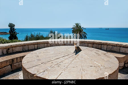 Roman sundial vintage large round stone on a hill above the sea in Sunny cloudless day Stock Photo