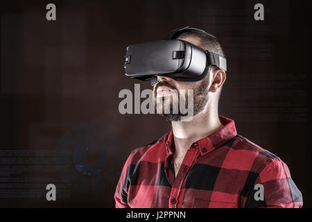 Young bearded man wearing virtual reality glasses Stock Photo