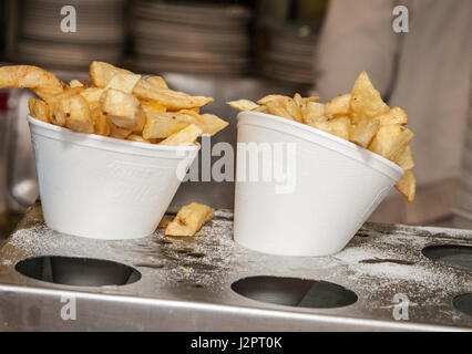 Fried potato chips in polystyrene cones in a fish and chip shop Stock Photo