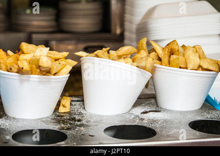 Fried potato chips in polystyrene cones in a fish and chip shop Stock Photo