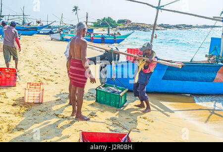 HIKKADUWA, SRI LANKA - DECEMBER 4, 2016: The fishermen will carry the fresh catch to the local fish market after the weighing, on December 4 in Hikkad Stock Photo