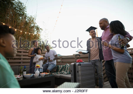 African American family celebrating graduation on summer deck