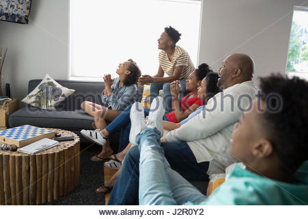 African American family watching TV in living room