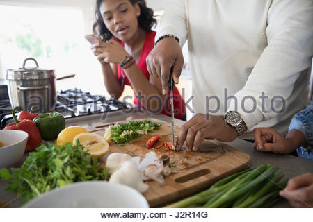 African American father and daughter cooking in kitchen