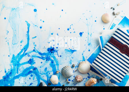 Marine travel flatlay with seashells, sketchbook, magnifying glass, sunglasses and compass drawing on a watercolor background Stock Photo