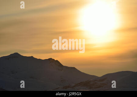 huge golden sunset over snowy mountain peak background Stock Photo - Alamy