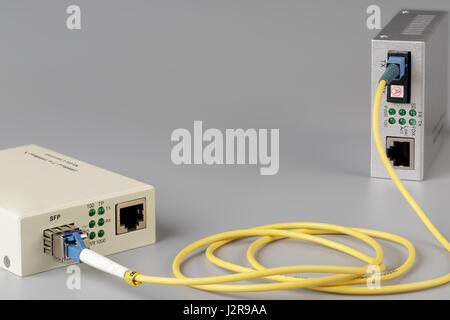 Two media converters connected by cable optical fiber Stock Photo