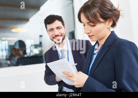 Young woman as trainee taking notes during her business apprenticeship Stock Photo