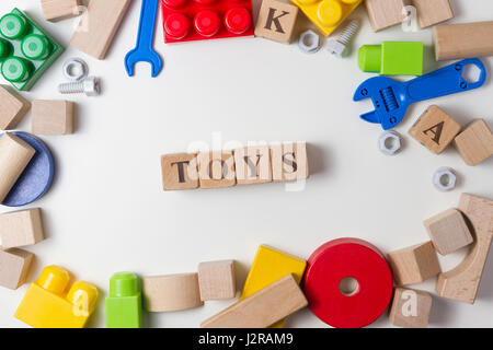 Toys word written in wooden cubes. Children toy on white background as frame with copy space for text. Top view Stock Photo