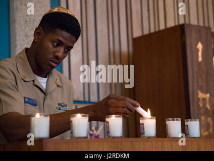 170424-N-WC566-0014 PEARL HARBOR (April 24, 2017)  Chief Jones lights the six Yartzeit candles, to represent the 6 million Jewish lives lost in the Holocaust, during a Holocaust Remembrance Ceremony held at the Aloha Jewish Chapel on Joint Base Pearl Harbor-Hickam. This year’s theme is, “The Strength of the Human Spirit”, and featured Dr. Daniel Bender, volunteer lay leader at Aloha Jewish Chapel, as the guest speaker.(U.S. Navy Photo by Mass Communications Specialist 2nd Class Gabrielle Joyner) Stock Photo