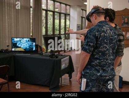 BANGOR, Wash. (April 27, 2017) Lt. Cmdr. Cal Kimes, from Bellingham, Washington, assigned to Trident Training Facility (TTF) Bangor, tests HoloLens device, which allows users to virtually experience how to move within a model engine, during the Innovation Lab (iLab) roadshow held at Trident Training Facility Bangor. The iLab, which is located at Naval Submarine Training Center Pacific, in Pearl Harbor, Hawaii, is an initiative launched to spur the rapid development of ideas and concepts to actionable use in submarine warfare. (U.S. Navy photo by Mass Communication Specialist 1st Class Amanda R Stock Photo