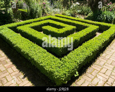 Square spiral of box yew hedging with block paver path, Barnsdale Gardens, Oakham, Rutland, Leicestershire, England, UK Stock Photo