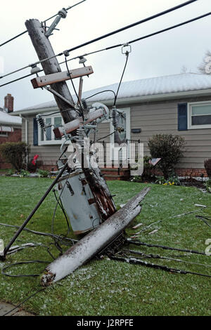 Fallen utility pole rests on the ground after spring winter storm cracks it in half in Willowick, Ohio, USA. Stock Photo