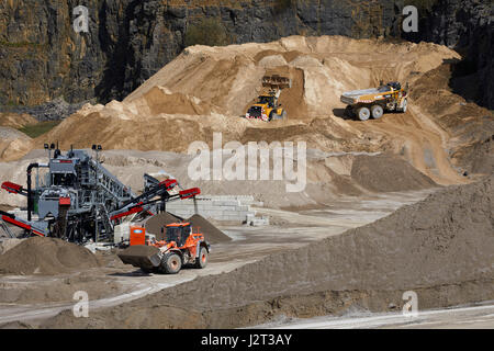 Diggers at Cemex Quarry in Dove Holes  High Peak district of Derbyshire nr Buxton. Stock Photo