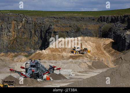 Diggers at Cemex Quarry in Dove Holes  High Peak district of Derbyshire nr Buxton. Stock Photo