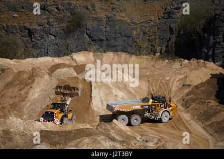 Diggers at Cemex Quarry in Dove Holes  High Peak district of Derbyshire nr Buxton. Stock Photo