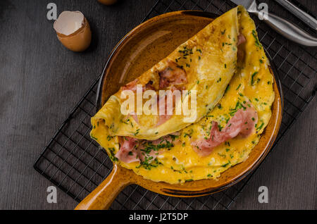 Ham and egg omelette, delicious and simple with fresh bread and herbs chive Stock Photo