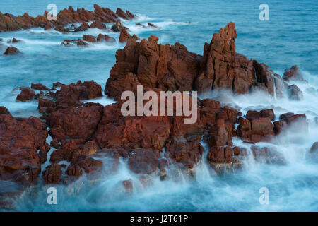 Two-second time exposure of a rough sea crashing on red rocks. Estérel Massif, Saint-Raphaël, Var, Provence-Alpes-Côte d'Azur, France. Stock Photo