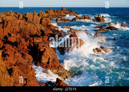 Last light of day on a rough sea crashing on red rocks. Estérel Massif, Saint-Raphaël, Var, Provence-Alpes-Côte d'Azur, France. Stock Photo