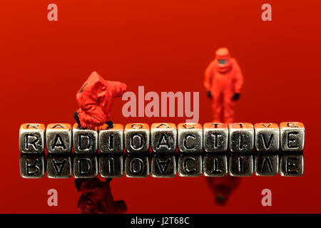 Miniature scale model team in chemical suits with the word radioactive on beads Stock Photo