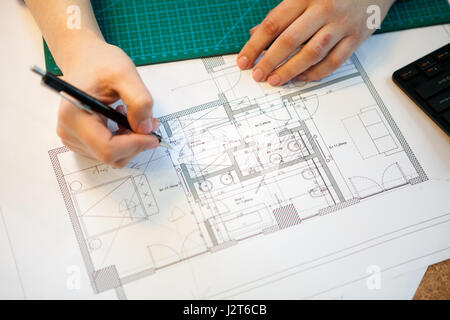 Architect working on blueprints on her table Stock Photo