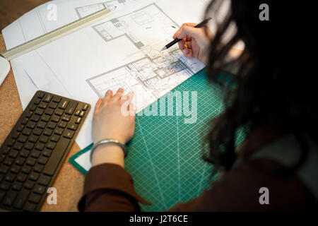 Architect working on blueprints on her table Stock Photo