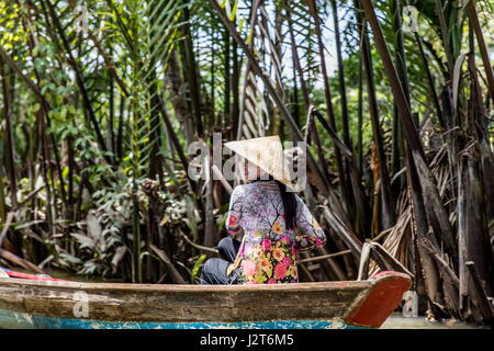 MEKONG DELTA, VIETNAM - FEBRUARY 21, 2017: Unidentified people in the boat at Mekong Delta in Vietnam. Boats are the main means of transportation in M Stock Photo