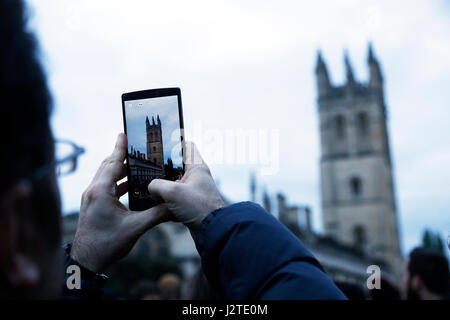 Oxford, UK. 1st May, 2017. New technology records the pagan tradition of May morning being celebrated in Oxford. May morning is traditionally celebrated in Oxford with a choir singing from the top of Magdalen College Tower after which the crowds are lead through the streets by Morris men who perform at various sites throughout the city. Credit: Jill Walker/Alamy Live News Stock Photo