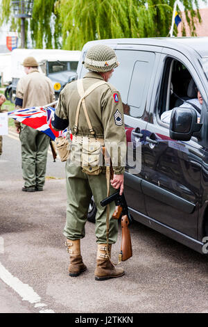 England, Sandwich. Salute to the 40s event. American GI soldier in world war two uniform stopping a car and talking to the driver at a road block. Stock Photo