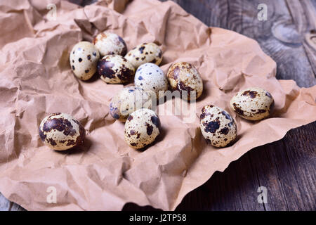 Fresh quail eggs on brown paper, close up Stock Photo
