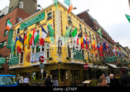 Flags outside colourful yellow Oliver St John Gogarty pub in Temple Bar area, Dublin city centre, Ireland, Republic of Ireland Stock Photo