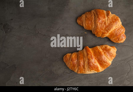 Top View of two fresh croissants on grey slate Stock Photo