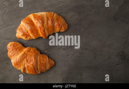 Top View of two fresh croissants on grey slate Stock Photo