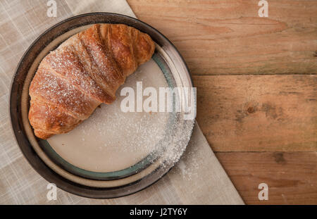 Top View of two fresh croissants dusted with icing sugar on a plate Stock Photo