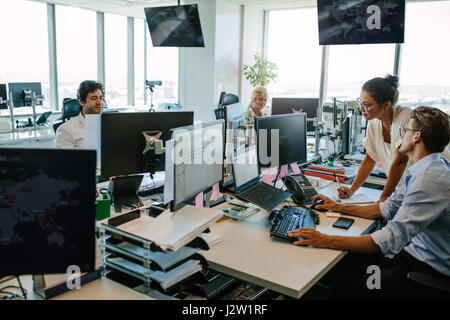 Business people working in modern office. Team working at desks in busy office.