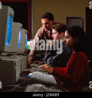 Middle school students and teacher in computer lab Stock Photo