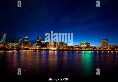 Wide panorama of illuminated night metal drawbridge across the Willamette River in downtown Portland with glowing lights waterfront skyscrapers Stock Photo