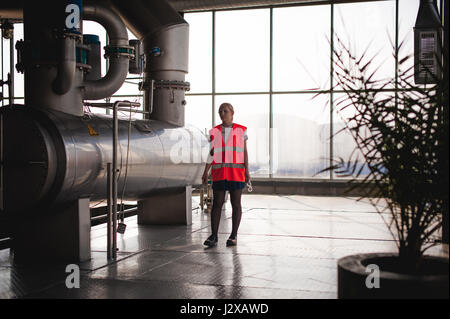 Female worker on beer factory. portrait woman in robe, standing on background line Food production, Inspection management control Equipment for produc Stock Photo