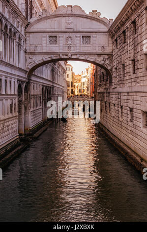 The famous Bridge of Sighs bathed in orange light at sunset in Venice, Italy Stock Photo