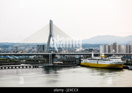 seaside view of cable-stayed aomori bay bridge with memorial ship 'Hakkoda-Maru', floating museum, in foreground. Stock Photo