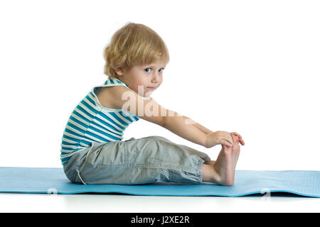 Child practicing yoga, stretching in exercise wearing sportswear. Kid isolated over white background Stock Photo