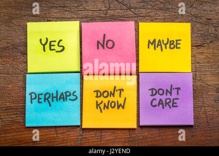 yes, no, maybe, perhaps, don't know, don't care -  undecided voter concept, colorful sticky notes against grunge rustic wood board Stock Photo