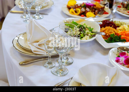 Decorated table ready for dinner. Beautifully decorated table set with flowers, candles, plates and serviettes for wedding or another event in the res Stock Photo