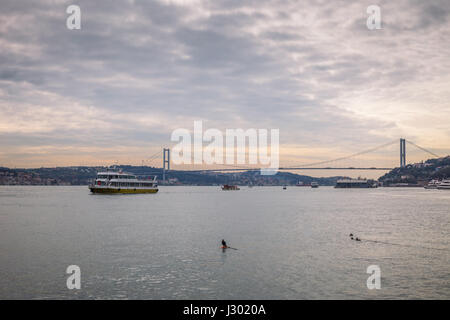 View of Bosphorus and the 15 July Martyrs Bridge (15 Temmuz Sehitleri Koprusu). Ferry approaching the first bridge at the Bosphorus in Istanbul, Turke Stock Photo