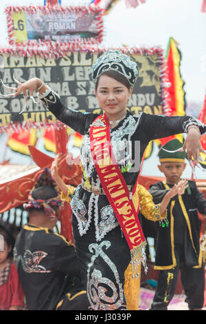 Unidentified young girl perform Traditional dance inside the  Bajau's boat called Lepa-Lepa decorated with colorfull Sambulayang flag during Regatta. Stock Photo