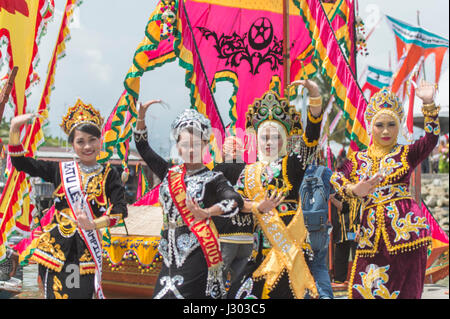 Unidentified young girl perform Traditional dance inside the  Bajau's boat called Lepa-Lepa decorated with colorfull Sambulayang flag during Regatta. Stock Photo