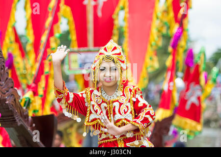 Unidentified young girl perform Traditional dance inside the  Bajau's boat called Lepa-Lepa decorated with colorfull Sambulayang flag during Regatta. Stock Photo