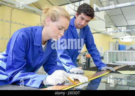 Young worker measuring length of strip Stock Photo
